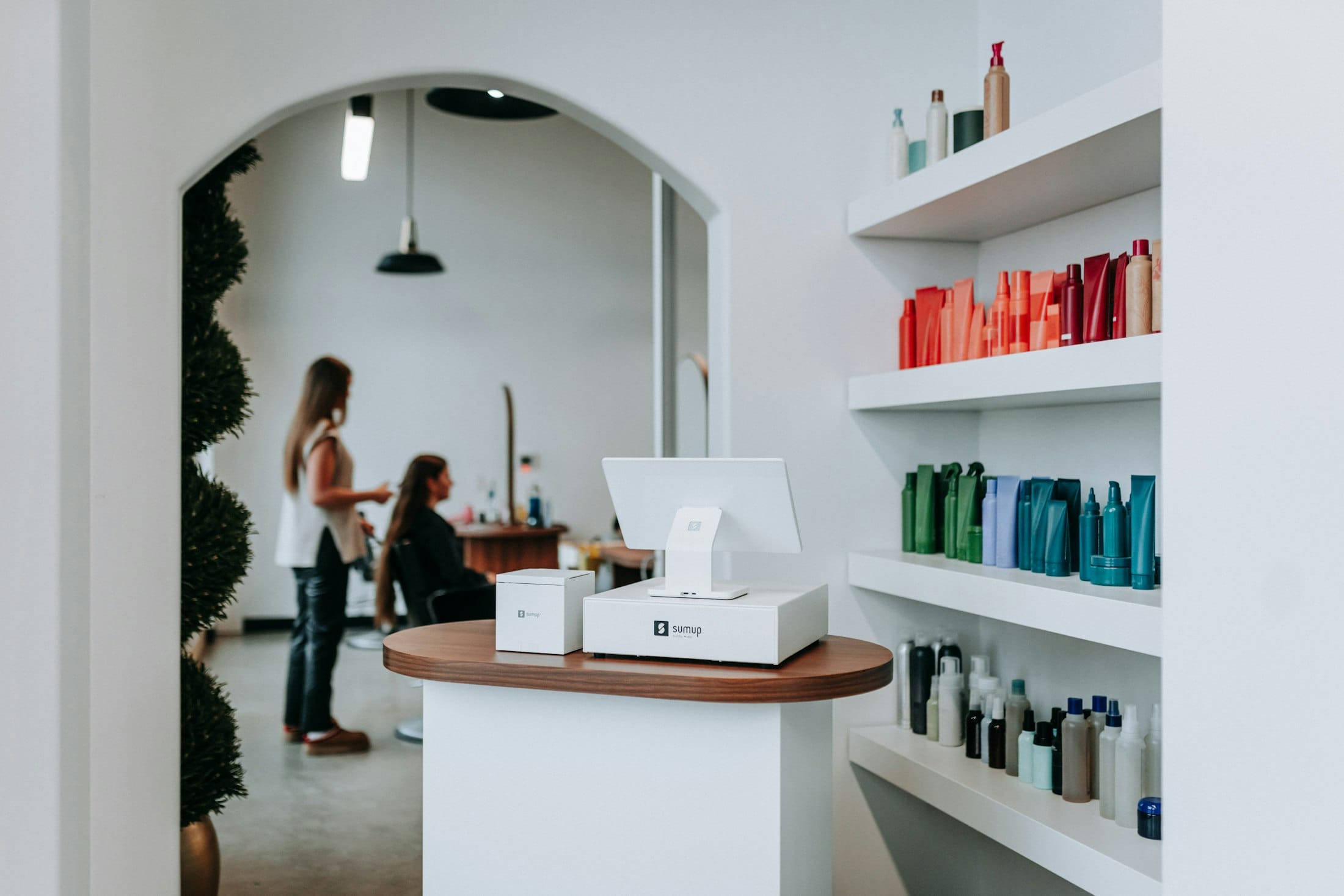Recepción de salón de belleza atendiendo a una clienta